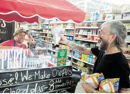  ?? R. Clayton McKee / For the Chronicle ?? Sean Carroll of Melange Creperie gives a banana Nutella crepe to Jason Kerr inside the H-E-B on Alabama at Dunlavy. Carroll says that he’ll be operating the cart for at least a year, if not longer. He’s there Monday-Wednesday from 3-7 p.m.