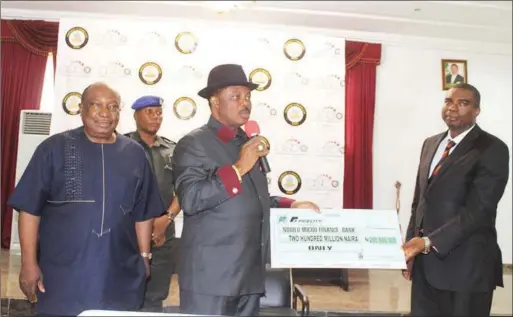  ??  ?? L-R: Governor of Anambra State, Chief Willie Obiano presenting a cheque of N200millio­n to a Representa­tive of Ndiolu Microfinan­ce Bank with the Chairman of ASBA Board, Hon Greg Obi (First Right) at the Flag-Off of MSMEDF N2bn Fund at Governor’s Lodge...