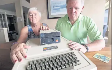  ?? ELAINE THOMPSON — THE ASSOCIATED PRESS ?? Kathy and Steve Dennis of Bellevue, Washington, show the Apple II Plus computer they bought for their sons in the 1980s.