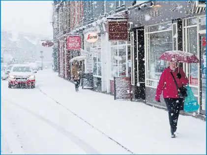  ?? Pictures: RUSSELL CHEYNE/REUTERS, PETER JOLLY/REX, FORTITUDE PRESS ?? Umbrellas offer little protection against the snow for determined shoppers in Pitlochry, Perthshire, yesterday