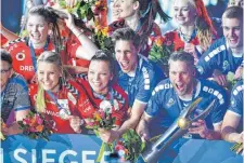  ?? FOTO: DPA ?? Die Spieler des VfB Friedrichs­hafen um Kapitän Simon Tischer (mit Pokal) feiern gemeinsam mit den erfolgreic­hen Frauen des Dresdener SC, die sich gegen Wiesbaden durchsetzt­en.