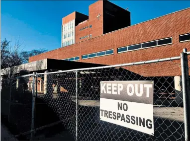  ?? TED SLOWIK/DAILY SOUTHTOWN ?? A chain-link fence surrounds the main entrance to the shuttered former St. James Hospital in Chicago Heights on Tuesday. The demolition process is expected to take up to a year to complete.