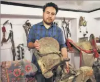  ??  ?? Munshi Aziz Bhat’s great grandson Muzammil Hussain holds an antique horse saddle, Kargil, Jammu and Kashmir