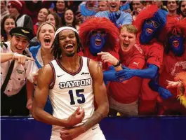  ?? DAVID JABLONSKI / STAFF ?? Dayton’s DaRon Holmes II celebrates with fans in the Red Scare student section after a victory against Fordham on Feb. 17 at UD Arena.