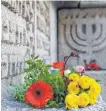  ?? FOTO: TOBIAS HASE/DPA ?? Blumen liegen am Gedenkstei­n der ehemaligen Münchner Hauptsynag­oge.