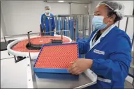  ?? Associated Press ?? A worker feeds vials for production of SARS CoV-2 Vaccine for COVID-19 at the SinoVac vaccine factory in Beijing last month. China said on Friday that it is joining the COVID-19 vaccine alliance known as COVAX.