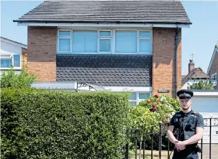  ??  ?? An officer outside the detached home of Joyce Burgess, 84, in Woking yesterday