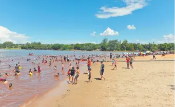  ?? ?? Numerosas personas, principalm­ente niños, disfrutan de la playa costanera Ñande Renda de CDE.