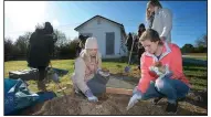  ?? NWA Democrat-Gazette/ANDY SHUPE ?? Sydney Middlebroo­k (right) of Fayettevil­le and Kari Pompeo (center) of Dallas, both freshmen at the University of Arkansas, pick rocks out of soil meant for a flower bed around the base of a sculpture Saturday.