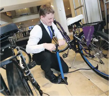  ?? MICHELLE BERG ?? Delta Bessboroug­h bellman Graham Rive pumps up the tires Tuesday on two new bicycles, which are free to use as part of Saskatoon’s Downtown Business Improvemen­t District free bike service program. Guests staying at eight hotels in the downtown will be...