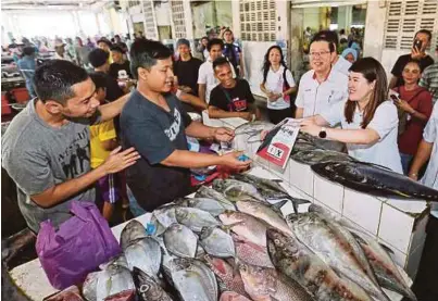  ?? [FOTO KHAIRULL AZRY BIDIN /BH] ?? Guan Eng bersama Vivian (kanan) melakukan tinjauan mesra di Pasar Umum, Sandakan, semalam.