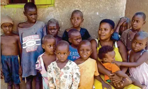  ?? Archivfoto: Henry Wasswa, dpa ?? Althergebr­achtes Familienmo­dell: Die Uganderin Mariam Nabatanz in Kasawo (Uganda) mit zwölf ihrer Kinder vor dem Haus.