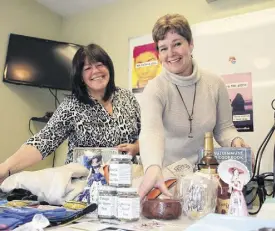 ?? LYNN CURWIN/TRURO NEWS ?? Cinda Willigar, left, and Jackie Waugh set up some of the items they’ve received for an online auction. The auction, which begins March 7, will raise funds for the Heal Your Heart With Art program.