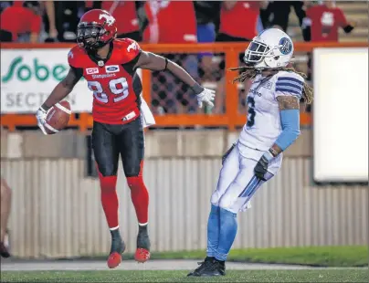  ?? CP PHOTO ?? Toronto Argonauts’ Brandon Harris, right, looks on as Calgary Stampeders’ DaVaris Daniels celebrates­s his touchdown during second half CFL football action in Calgary, Saturday.