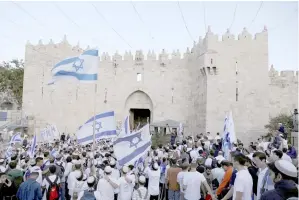  ??  ?? Israelis celebrate as they hold Israeli flags during a parade marking the annual Jerusalem Day, at Damascus Gate. — Reuters photo