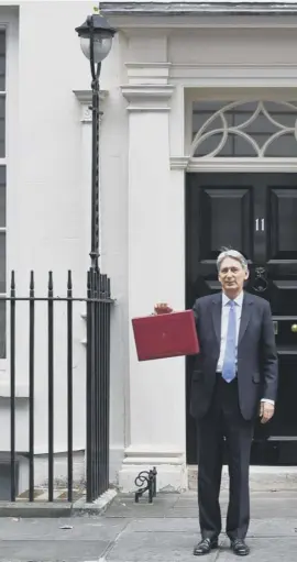  ??  ?? Chancellor Philip Hammond poses outside No 11 before going to the Commons to make his Budget speech in which he unveiled £2bn of funding for Scotland