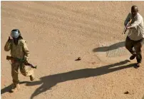  ?? AP ?? A plain-clothed policeman points his rifle at protesters during clashes in Khartoum. —