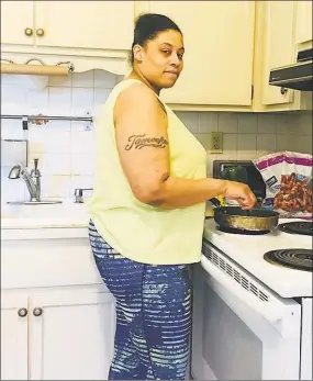  ?? Conn. Health I-Team ?? Tameeka Coleman, of Bridgeport, prepares a meal for her six younger children while taking a break from caring for her newborn.