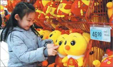  ?? LI TIECHENG / FOR CHINA DAILY ?? A girl chooses decoration­s in Jinzhou, Liaoning province, for the upcoming Spring Festival, which falls on Jan 28.