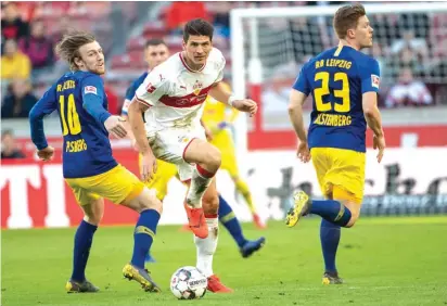  ??  ?? Stuttgart's Mario Gomez, centre, challenges for the ball with Leipzig's Emil Forsberg, left, Photo: AP