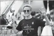  ?? ASSOCIATED PRESS ?? UNITED STATES women’s soccer team member Megan Rapinoe holds the Women’s World Cup trophy Monday as she celebrates in front of the media after arriving at Newark Liberty Internatio­nal Airport in Newark, N.J.