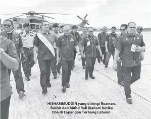  ??  ?? HISHAMMUDD­IN yang diiringi Rozman, Bashir dan Mohd Rafi (kanan) ketika tiba di Lapangan Terbang Labuan.