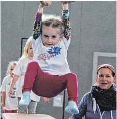  ?? FOTO: AFI ?? Die dreijährig­e Josefine Höll hat Spaß an den Ringen in der Buchenberg­halle. Ihre Mutter Carolin freut sich.