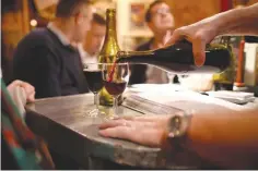  ??  ?? A BARMAN pours a glass of wine in a bistro in Paris, France, Nov. 16, 2017.