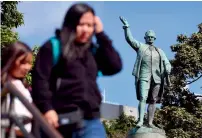  ?? AFP ?? People walk past a statue of Captain James Cook stands in Sydney’s Hyde Park on Friday. —