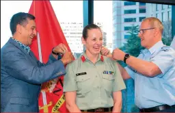  ??  ?? BRIGADIER ROSE KING’S HUSBAND, LIEUTENANT COLONEL GLENN KING, ALONG WITH AIR MARSHAL SHORT, HELPED CHANGE HER RANK SLIDES ON HER UNIFORM DURING THE CEREMONY.