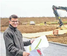  ?? FOTO: SABINE RÖSCH ?? Bürgermeis­ter Jochen Fetzer blickt auf die Pläne. Auf dem ersten Baugrundst­ück haben die Arbeiten bereits begonnen.