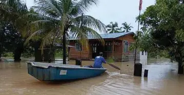  ?? ?? SEORANG penduduk Kampung Gudang Rasau, Kuantan menaiki bot untuk memindahka­n barang. - Gambar NSTP/ASROL AWANG