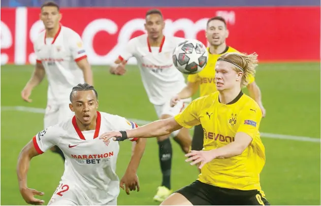  ?? Associated Press ?? ↑
Dortmund’s Erling Haaland (right) vies for the ball with Sevilla’s Jules Kounde during their Champions League match on Wednesday.