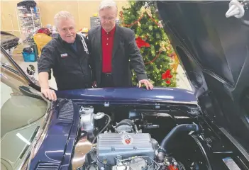  ??  ?? Corvette restoratio­n partners Mike Boivin and Ian Mitchell look at the fuel-injected engine 1963 Corvette sport coupe that Boivin restored after rescuing it from a Christmas tree farm in the Fraser Valley.