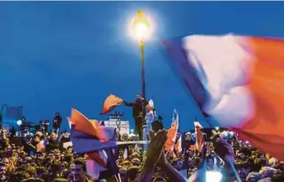  ??  ?? Supporters of French presidenti­al candidate Emmanuel Macron celebratin­g at the Carrousel du Louvre on Sunday.