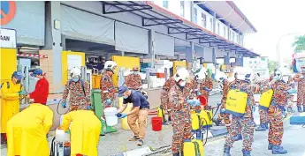  ??  ?? Firefighte­rs get ready for the disinfecti­on works on Stutong Community Market.