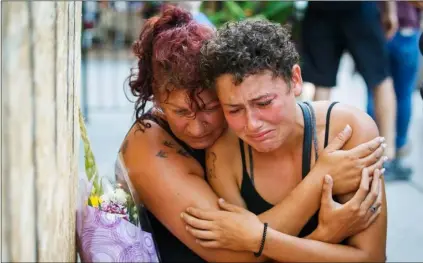  ?? MARK BLINCH/THE CANADIAN PRESS VIA AP ?? Desirae Shapiro, 19 (right) and her mother, Gina Shapiro, friends of 18-year-old Danforth shooting victim Reese Fallon, mourn after visiting a makeshift memorial, on Monday in Toronto, rememberin­g the victims of the shooting on Sunday.