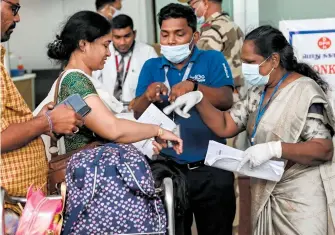  ?? AFP ?? Personal busca síntomas del virus en pasajeros en un aeropuerto de India