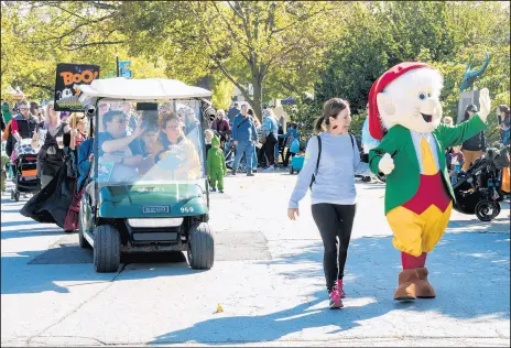  ?? KELLY TONE ?? Columnist Phil Potempa, left, and his parents Chester and Peggy, seated behind, ride in the Oct. 19 “Boo! At the Zoo” Halloween Costume Parade led by the Keebler Cookie Co.’s Ernie the Elf.