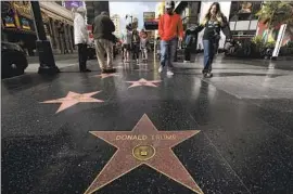  ?? Genaro Molina Los Angeles Times ?? VISITORS walk near former President Trump’s star on the Hollywood Walk of Fame on Dec. 22. An effort is underway to have the star removed.