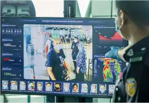  ??  ?? First sign: Authoritie­s checking passengers as they go through temperatur­e checks at Kota Kinabalu Internatio­nal Airport.