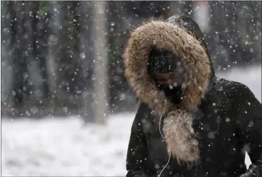  ?? MARK LENNIHAN— ASSOCIATED PRESS ?? In this Dec. 17, 2020, file photo, a woman walks through a snowstorm in the Bronx borough of New York.