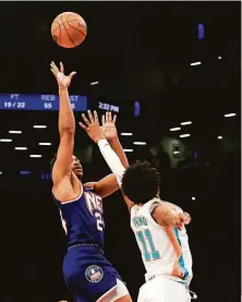  ?? Jessie Alcheh / Associated Press ?? Brooklyn guard Cam Thomas shoots the game-winning basket over San Antonio’s Joshua Primo in overtime.
