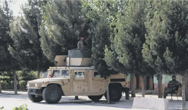  ??  ?? 0 Afghan security forces along a roadside in Kunduz yesterday after the Taliban captured Afghanista­n’s main border crossing with Tajikistan