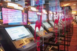  ?? Emily Matthews/Post-Gazette ?? The Plexiglas installed between kiosks on the gaming floor of Rivers Casino is an example of the effects that COVID-19 had on casinos. Internet gaming made big gains while the casinos were closed.