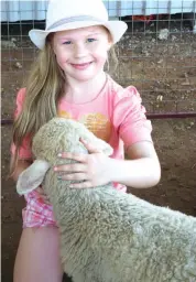  ??  ?? Sophie Ketteringh­am cuddles a sheep in the animal enclosure at last year’s Neerim District Country Show.