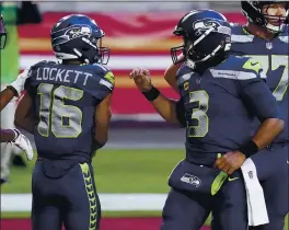  ??  ?? Seahawks wide receiver Tyler Lockett, left, celebrates his second touchdown reception of the game with quarterbac­k Russell Wilson. Lockett finished with 12 catches.