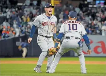  ?? (AP PHOTO/JOHN MINCHILLO ?? Houston Astros third baseman Alex Bregman (2) and first baseman Yuli Gurriel (10) celebrate after the Astros defeated the New York Yankees 6-5 to win Game 4 and the American League Championsh­ip Series on Monday.