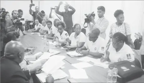  ?? (Photo by Terrence Thompson) ?? General Secretary of the Guyana Teachers’ Union Coretta McDonald (right) and President Mark Lyte (second from right) sign the Terms of Resumption on behalf of the union.