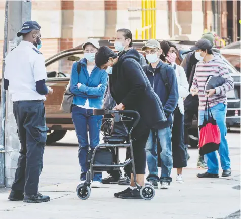  ?? PETER J THOMPSON / NATIONAL POST ?? People line up for access to a Service Canada location in Toronto on Friday, as Ontario prepared to reintroduc­e restrictio­ns in certain areas.